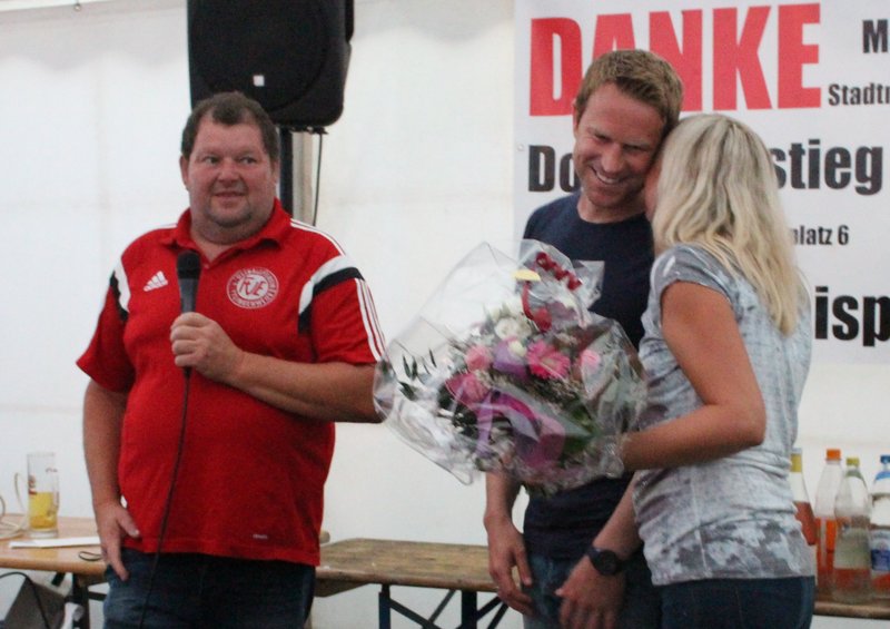 Ein Paar hält Blumen an einem Tisch, das Bild strahlt Freude und Zuneigung aus