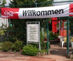 Rotes und weißes Banner mit dem Schriftzug "Willkommen" in klarer, einladender Schriftart
