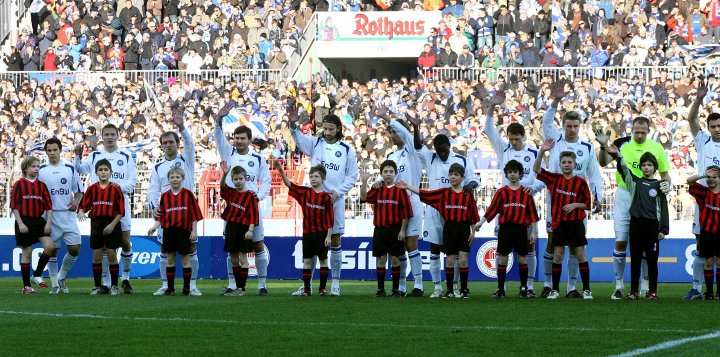 Fußballspieler stehen auf dem Feld und zeigen Teamgeist in einer gemeinsamen Pose