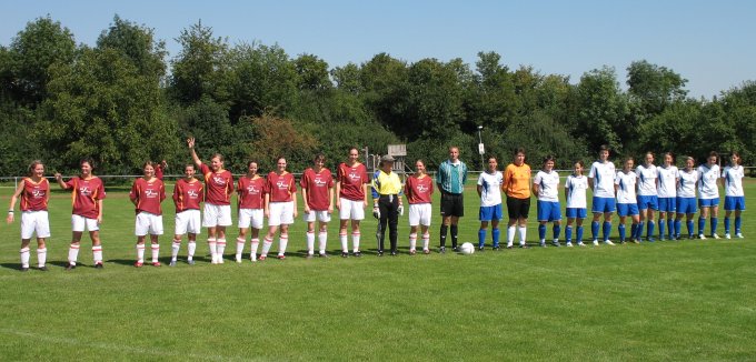 Männer stehen auf einem Fußballfeld und diskutieren die Spielstrategie