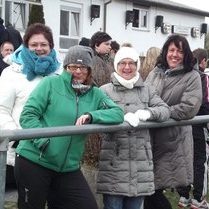 Mehrere Frauen stehen zusammen und posieren lächelnd für ein Foto.