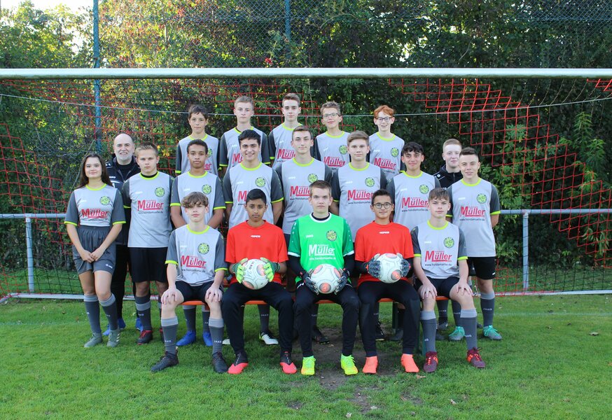 Die Spieler einer Fußballmannschaft stehen vor einem Tor für ein Gruppenfoto.