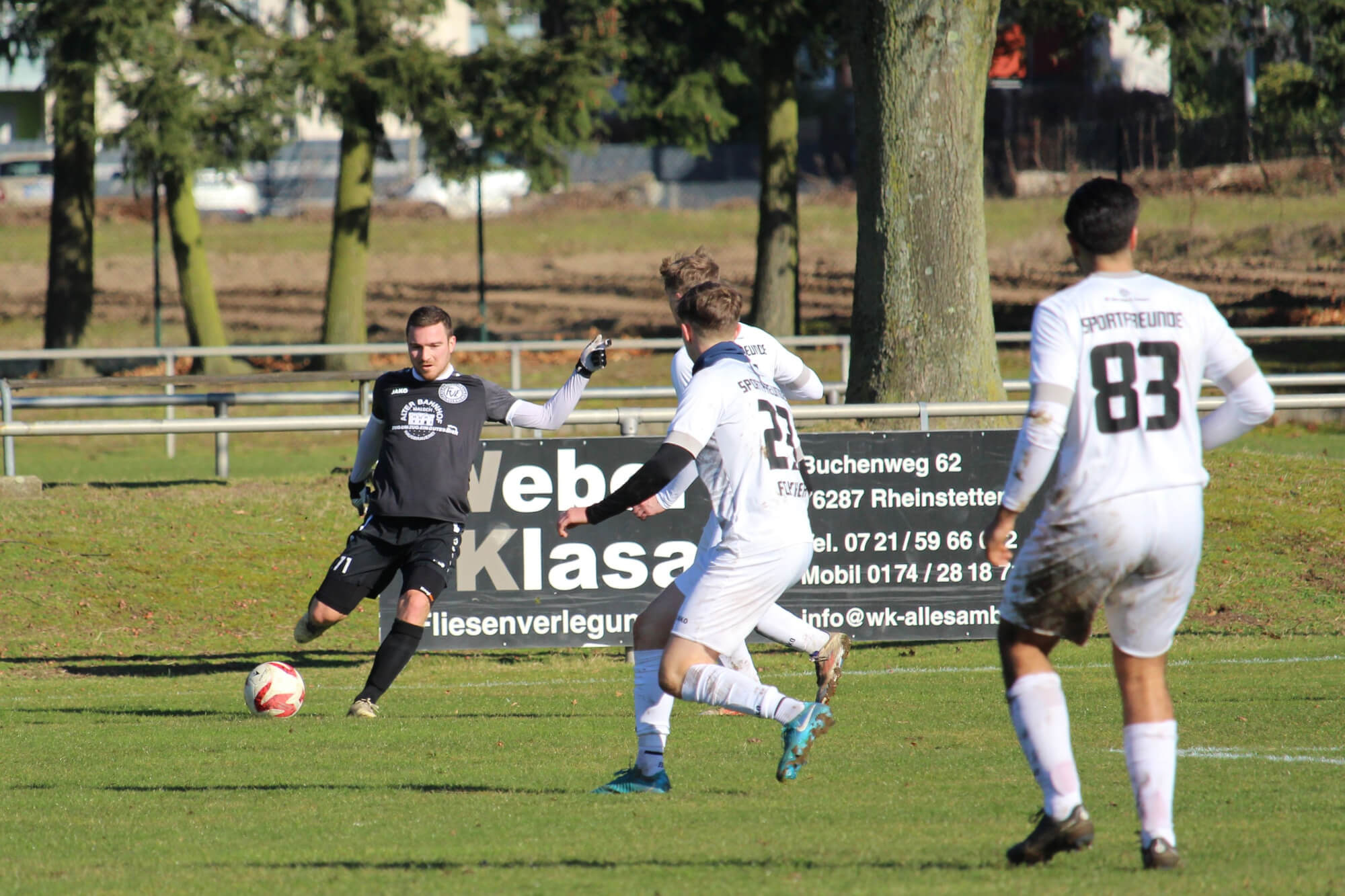 Eine Gruppe von Männern, die auf einer Wiese ein Fußballspiel austragen und dabei Teamwork und Sportlichkeit unter Beweis stellen.