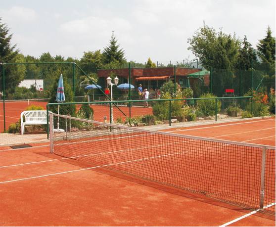 Ein gepflegter Tennisplatz mit einem Netz in der Mitte, ideal für sportliche Aktivitäten.