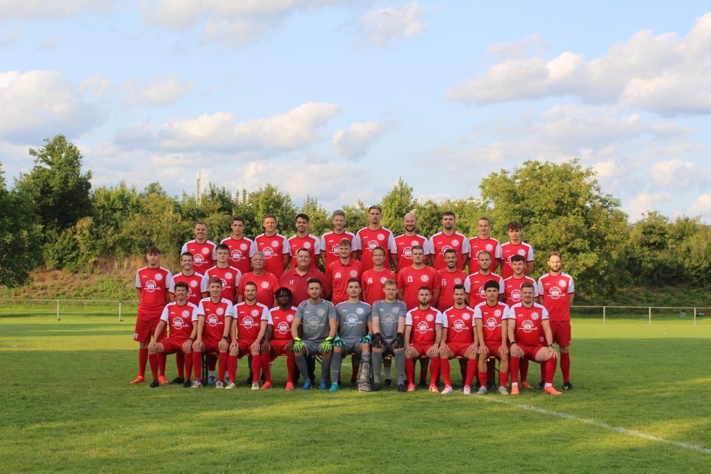 Mannschaftsbild mit allen Spielern der 1. Mannschaft in 3 Reihen in den roten Trikots