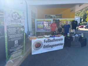 Dominik Kuitja, Lara Schulte und Norbert Revfi an unserem Stand mit Kuchenverkauf und FVE-Banner vor der Netto-Filiale in Spessart