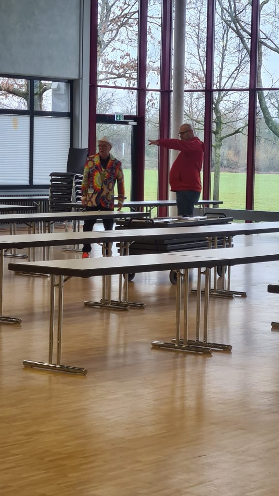 2 Männer beim Aufbau der Stühle und Tische