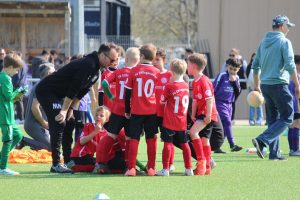 Gruppenbild der F-Jugend Spieler in einem Kreis mit den Trainern